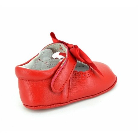 Merceditas de piel color rojo con detalle de lazo decorativo, cierre de velcro y suela antideslizante, ideales para mantener a tu bebé cómoda y con estilo.